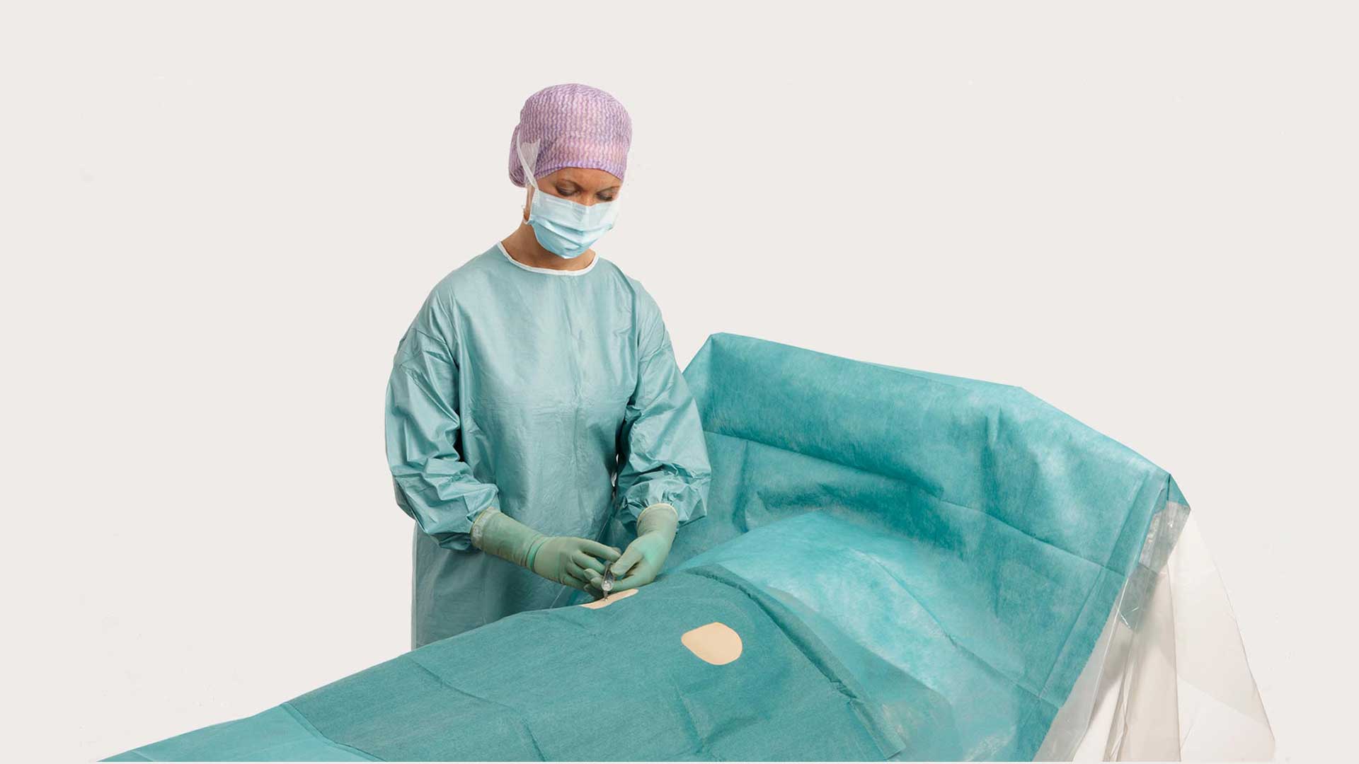 een chirurg gebruikt een BARRIER angiografie afdeklaken voor een operatie
