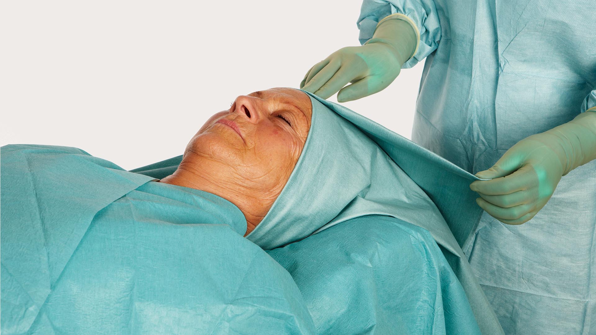 hoofd van een vrouwelijk patiënt, afgedekt met een barrier kno afdeklaken