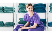 vrouwelijke verpleegkundige die een BARRIER omlooppak draagt, zit in een kleedkamer
